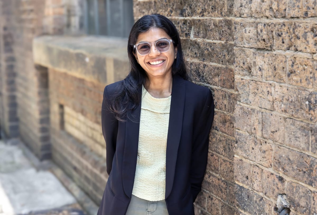 Hero image woman leaning against brick wall Anmol Panjwani